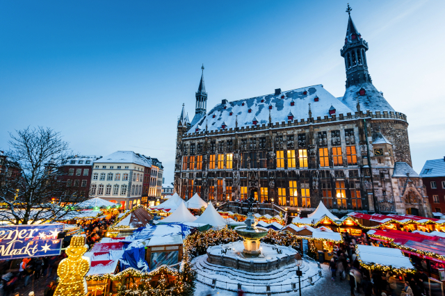 Weihnachtlich beleuchteter Aachener Weihnachtsmarkt vor dem historischen Rathaus – ideal für stimmungsvolle Adventsreisen mit dem Bus.