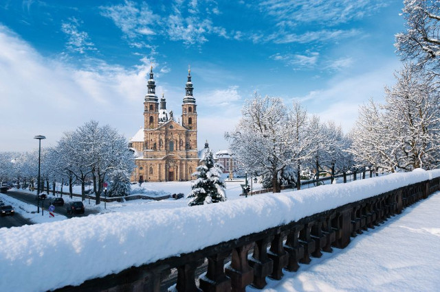 Verschneiter Dom in Fulda unter blauem Winterhimmel – festliche Atmosphäre und beliebtes Ziel für Silvester Busreisen in Deutschland.