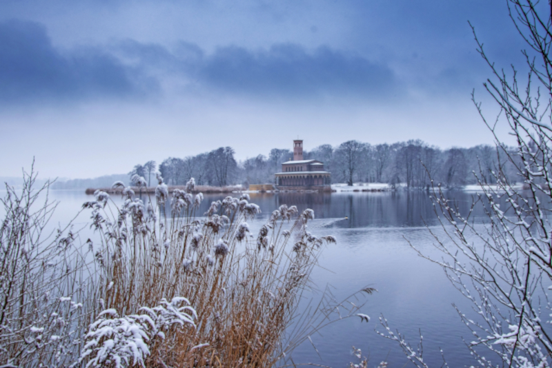 Winterzauber in Potsdam – besinnliche Weihnachtsreisen mit dem Bus Winterliche Landschaft am Sacrower See mit der Heilandskirche bei Potsdam – stimmungsvolles Motiv für festliche Weihnachtsreisen mit dem Bus.