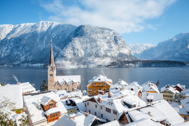 Verschneites Hallstatt im Salzkammergut mit Blick auf See und Berge – traumhafte Kulisse für stimmungsvolle Silvester Busreisen.