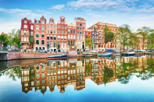 Sommerliche Grachtenkulisse mit historischen Giebelhäusern in Amsterdam – ein stimmungsvolles Ziel für Städtereisen
