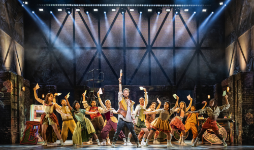 Farbenfrohe Bühnenszene mit dynamischem Ensemble und festlicher Stimmung inspirierende &Julia Musical Tagesfahrt