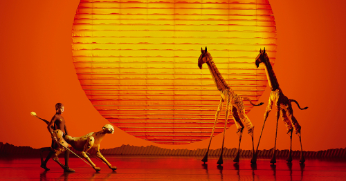 Leuchtende Savannenszenerie mit Giraffen- und Tierpuppen vor großem Sonnenaufgang – stimmungsvolle Musical Tagesfahrt