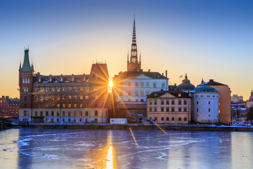 Winterliches Stockholm mit gefrorenem Wasser und goldenem Sonnenaufgang – stimmungsvolle Inspiration für eine Städtereise Stockholm