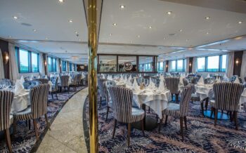 Stilvolles Bordrestaurant der Viva Moments mit elegant gedeckten Tischen und großen Panoramafenstern für genussvolle Stunden an Bord