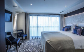 Komfortable Doppelkabine der Viva Moments mit großem Panoramafenster, elegantem Doppelbett und stilvollem Ambiente für entspannte Tage an Bord