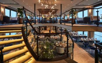Großzügiger Restaurantbereich der Viva Two mit eleganter Treppe, modernem Design und Panoramafenstern für genussvolle Momente an Bord
