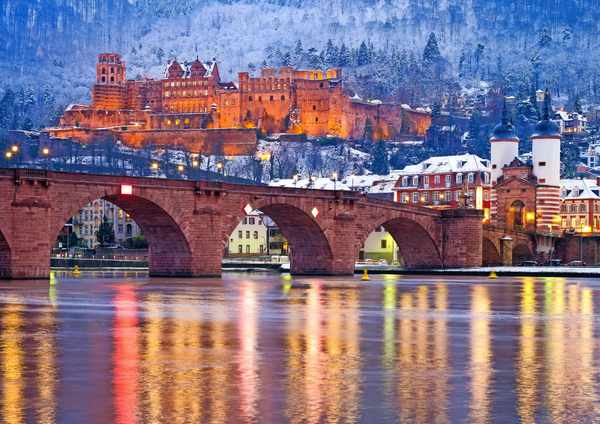 Beleuchtetes Heidelberger Schloss über der Alten Brücke am Neckar im Winter – Ausflugsziel bei der Silvesterreise nach Mannheim