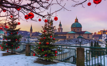 Weihnachtlich geschmückte Tannenbäume vor der winterlichen Altstadt von Salzburg mit Salzburger Dom – Ausflugsziel der Weihnachts- und Silvesterreise in die Wachau