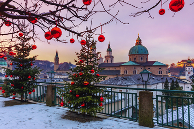 Weihnachtlich geschmückte Tannenbäume vor der winterlichen Altstadt von Salzburg mit Salzburger Dom – Ausflugsziel der Weihnachts- und Silvesterreise in die Wachau