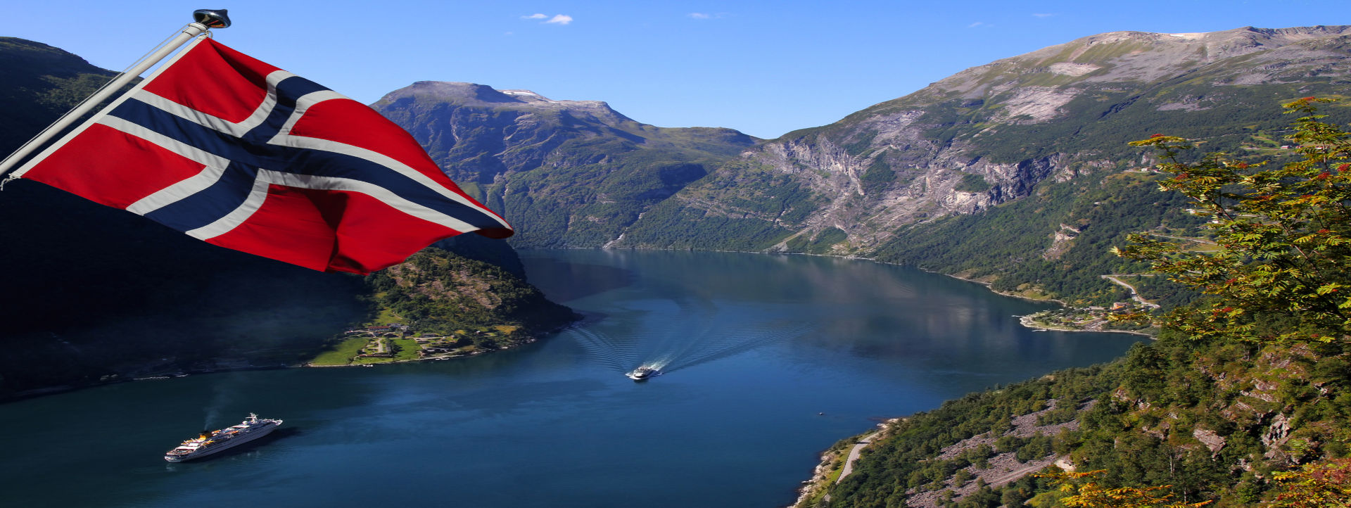 Norwegische Flagge vor einer Fjordlandschaft – Reiseziel für Busreisen nach Norwegen