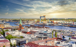 Luftaufnahme von Kiel mit Hafen und Stadtansicht bei Sonnenuntergang.