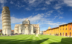 Schiefer Turm von Pisa und umliegende Gebäude bei klarem Himmel.