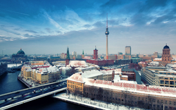 Winterliche Stadtansicht von Berlin mit Fernsehturm und verschneiten Dächern.