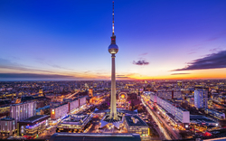 Fernsehturm Berlin bei Sonnenuntergang über der Stadtlandschaft.