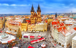 Marktplatz mit Weihnachtsmarkt und Kirche in einer historischen Altstadt im Winter.