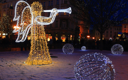 Leuchtender Weihnachtsengel in verschneiter Stadtlandschaft bei Nacht