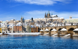 Schneebedeckte Prager Burg mit Blick auf die Karlsbrücke und die Moldau.