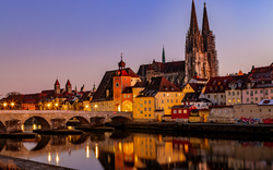 Stadtansicht von Regensburg mit Dom und Steinbrücke am Abend.