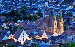 Abendansicht der Stadt Beilngries mit beleuchteter Kirche und umliegenden Häusern.