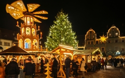 Weihnachtsmarkt in Weimar bei Nacht mit Lichtern und Menschen.