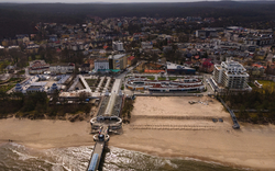 Luftaufnahme von Międzyzdroje an der Ostseeküste in Polen, mit Strand, Meer und umliegender Stadt.