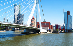 Moderne Schrägseilbrücke über Fluss mit Stadt im Hintergrund bei klarem Himmel