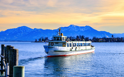 Ein Boot auf einem See mit schneebedeckten Bergen im Hintergrund.