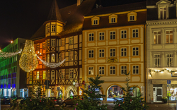 Beleuchtete Fachwerkhäuser bei Nacht mit Weihnachtsdekorationen.