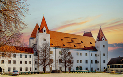 Neues Schloss in Ingolstadt, Deutschland, mit roten Dächern und mehreren Türmen im Abendlicht.