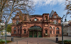 Historisches Gebäude mit roter Sandsteinfassade und dekorativen Elementen.