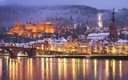 Heidelberg bei Nacht mit beleuchtetem Schloss und Alter Brücke im Winter.