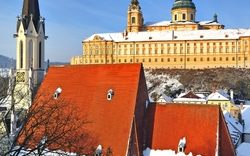 Kloster Melk in Österreich im Winter, mit schneebedeckten Gebäuden und blauem Himmel.