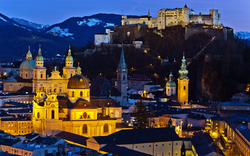 Blick auf Salzburg bei Dämmerung mit Festung Hohensalzburg im Hintergrund.