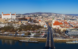 Stadtpanorama mit Burg und Fluss im Vordergrund.