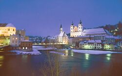 Verschneite Stadtansicht bei Nacht am Zusammenfluss von Enns und Steyr