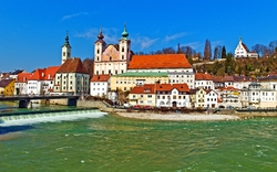 Flusslandschaft mit historischen Gebäuden an einem sonnigen Tag.
