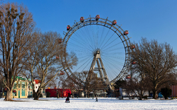 Riesenrad im Winter mit schneebedecktem Boden und Bäumen im Prater.