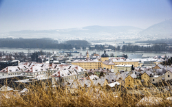Verschneite Stadtlandschaft mit Fluss im Hintergrund