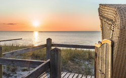 Strandkorb am Meer bei Sonnenuntergang.