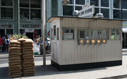Checkpoint-Attrappe mit Sandsäcken vor einem Laden in einer Stadtstraße.
