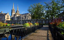 Kirche hinter Fluss, Brücke, Bäume und blauer Himmel