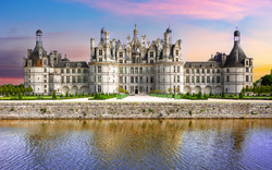 Schloss Chambord an einem ruhigen Fluss bei Sonnenuntergang.