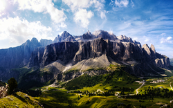 Panorama der Dolomiten mit grünen Tälern und klarem Himmel.