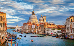 Blick auf den Canal Grande in Venedig mit Gondeln und historischen Gebäuden im Sonnenuntergang.