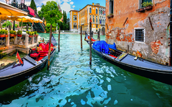 Zwei Gondeln auf einem Kanal in Venedig, flankiert von alten Gebäuden.