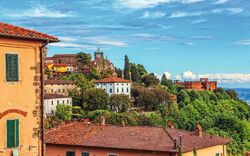 Bild von malerischem italienischem Dorf mit alten Gebäuden und Bäumen.
