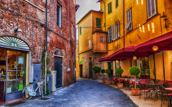 Schmale Gasse mit Café in historischer europäischer Altstadt.